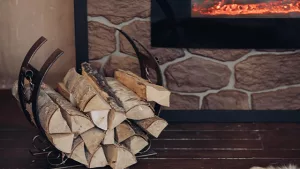 Tas de bûches de bois de chauffage sec à coté d'une cheminée poêle à bois sur un range buches