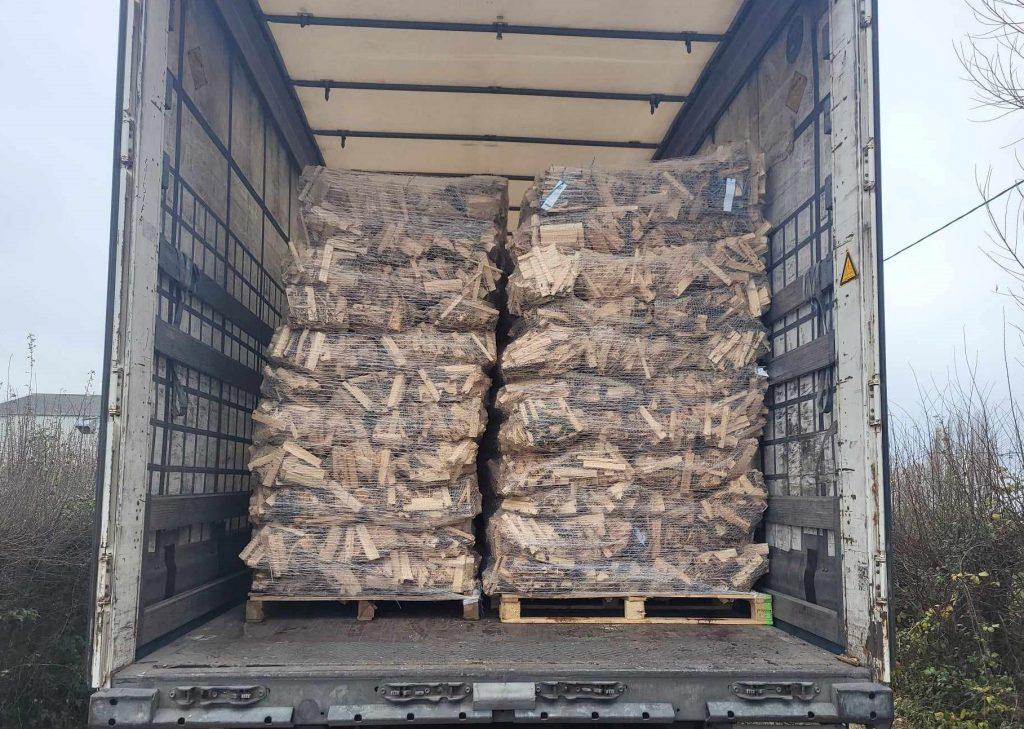 Camion d'un grossiste de bois de chauffage livrant des sacs de petit bois d'allumage fins et secs